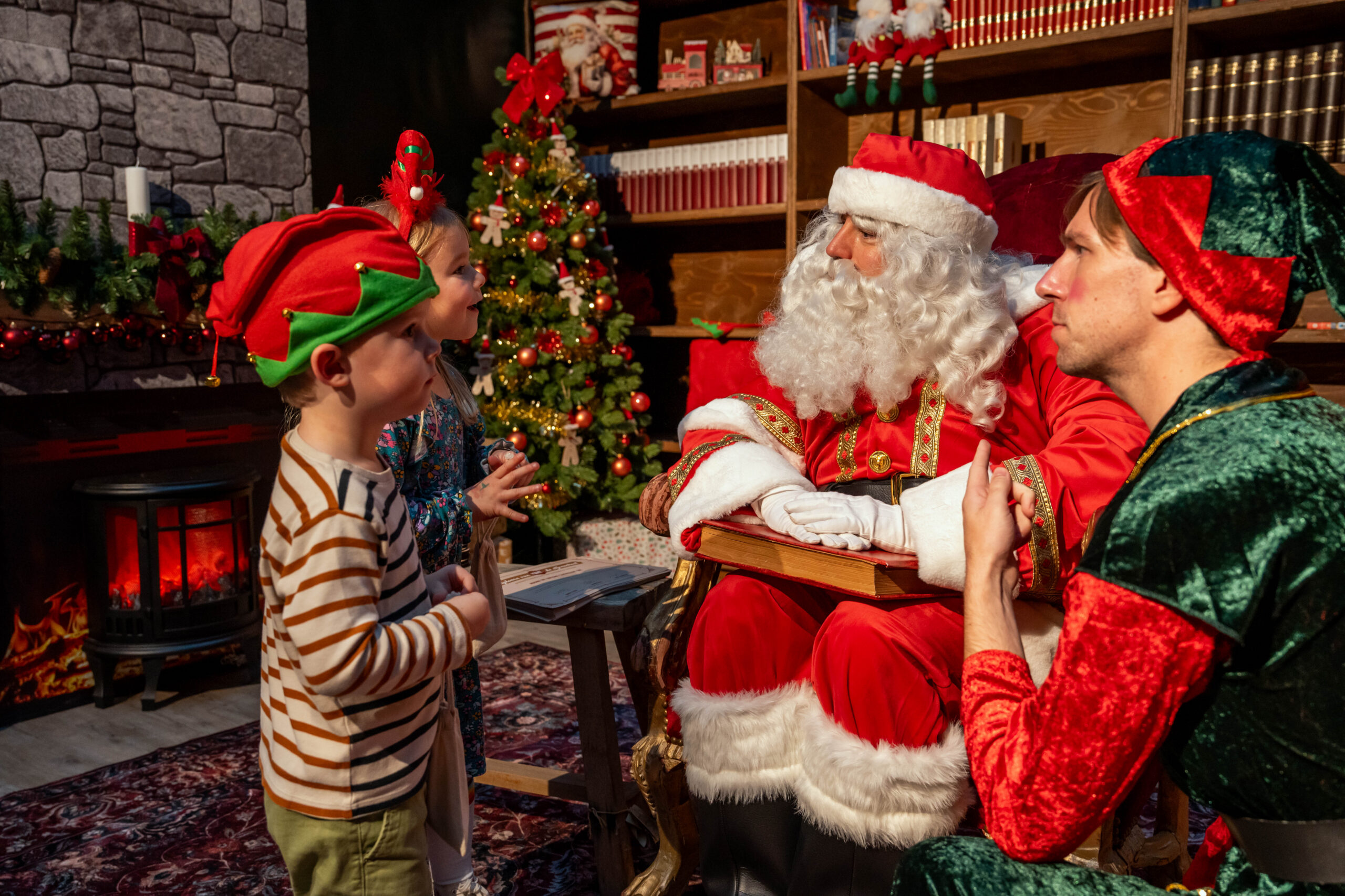 Kerstman met hulpelf ontvangen kinderen bij Tuincenter Claes